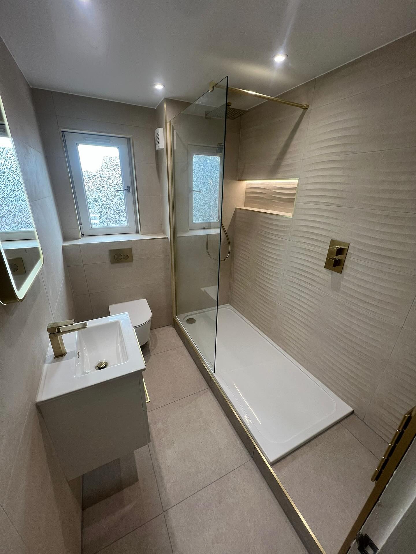 Textured-tile shower room with brass trim, fitted by CDM